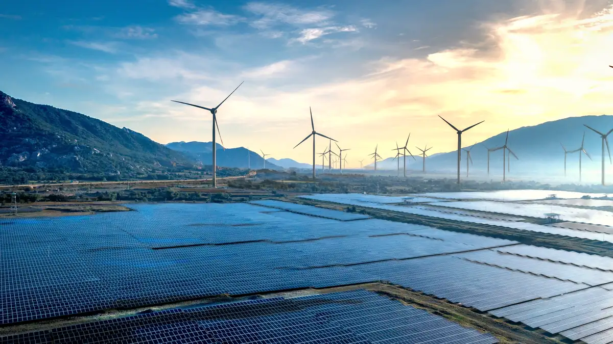 A solar park and wind turbines at sunset in a valley near Phan Rang, Vietnam